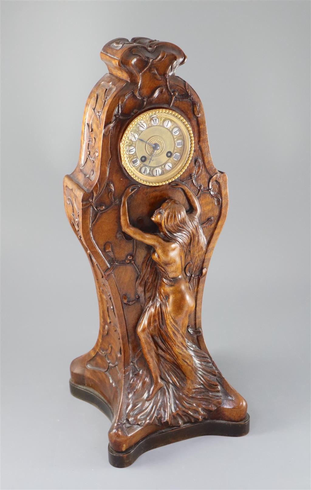 An unusual French Art Nouveau walnut mantel clock, width 9in. height 22.75in.